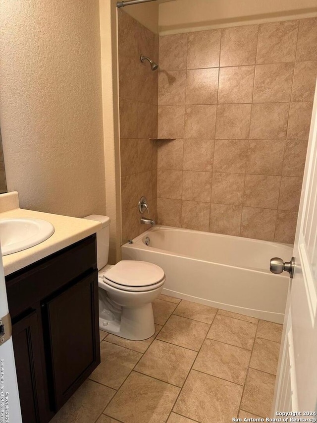 full bathroom with vanity, tiled shower / bath combo, and toilet