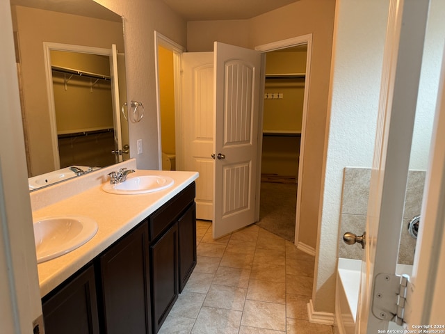 bathroom with tile patterned flooring, vanity, and a washtub