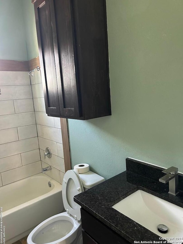 full bathroom with vanity, tiled shower / bath combo, and toilet