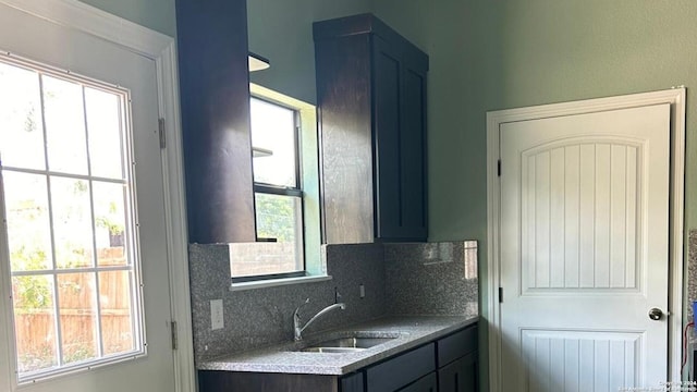 bathroom featuring backsplash, sink, and plenty of natural light