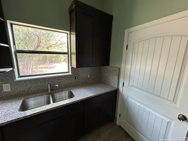 kitchen with sink, light stone countertops, and tasteful backsplash