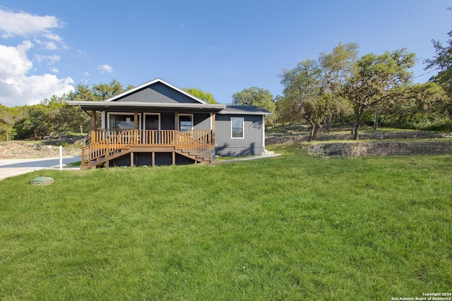 back of house featuring a porch and a yard