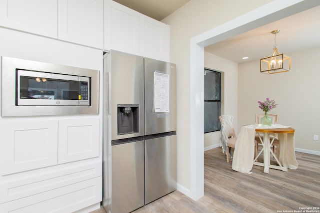 kitchen featuring white cabinetry, stainless steel refrigerator with ice dispenser, a chandelier, decorative light fixtures, and light hardwood / wood-style floors