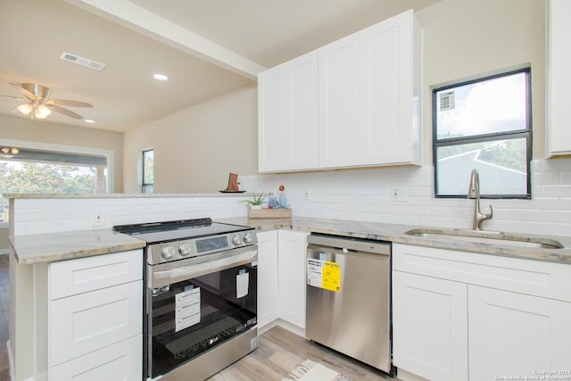 kitchen featuring white cabinets, sink, light wood-type flooring, light stone counters, and stainless steel appliances