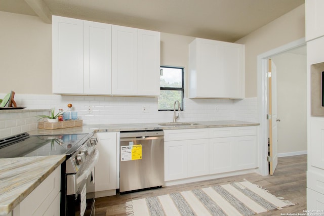 kitchen featuring sink, decorative backsplash, appliances with stainless steel finishes, light hardwood / wood-style floors, and white cabinetry