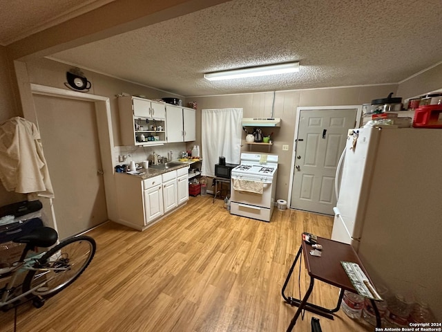 kitchen with light hardwood / wood-style flooring, white appliances, white cabinetry, and a textured ceiling