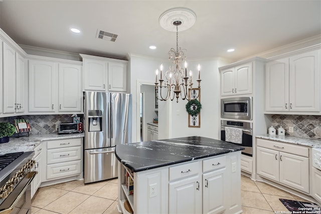 kitchen featuring light tile patterned flooring, stainless steel appliances, backsplash, and a center island