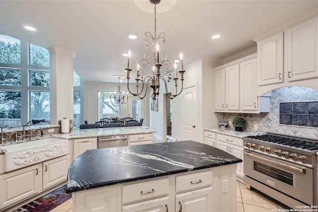 kitchen with tasteful backsplash, gas stove, light tile patterned floors, a kitchen island, and dishwasher