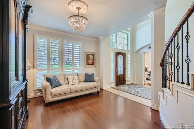 foyer entrance with a chandelier, dark hardwood / wood-style floors, and ornamental molding