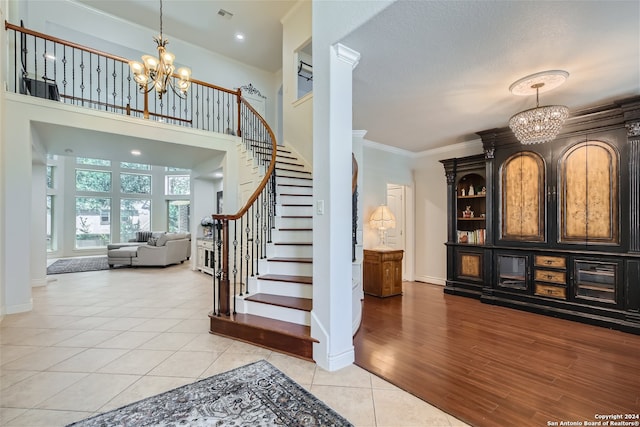 foyer entrance featuring a notable chandelier, light wood-type flooring, and ornamental molding