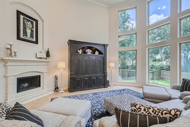 living room with crown molding, a towering ceiling, and light tile patterned floors