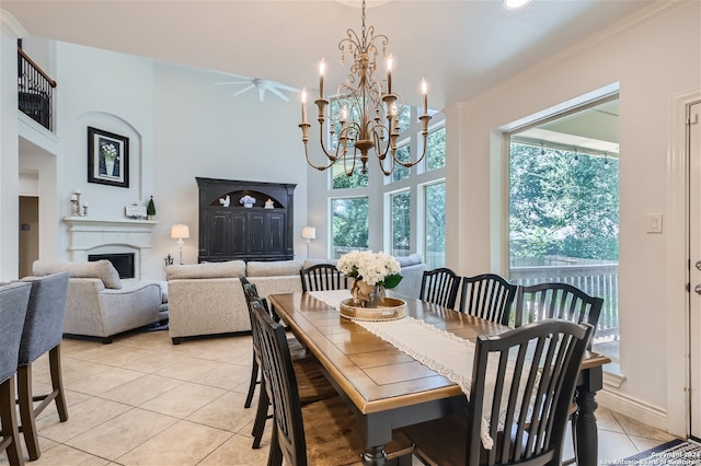 tiled dining area with ceiling fan with notable chandelier and plenty of natural light