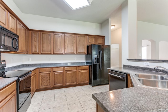 kitchen with black appliances, light tile patterned flooring, and sink