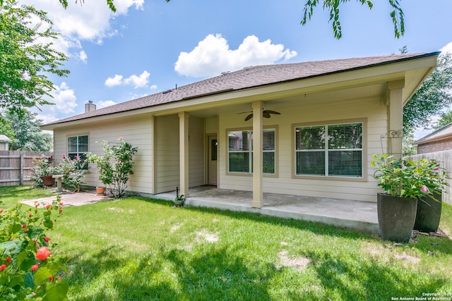 back of property with ceiling fan, a yard, and a patio