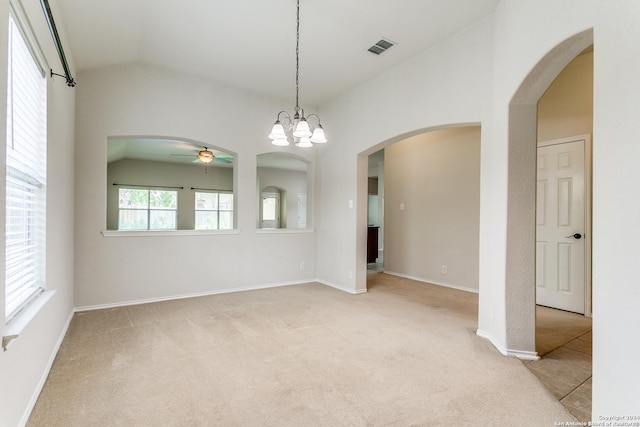 carpeted spare room featuring ceiling fan with notable chandelier and vaulted ceiling