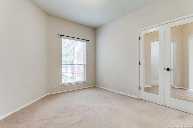 unfurnished bedroom with light carpet and french doors