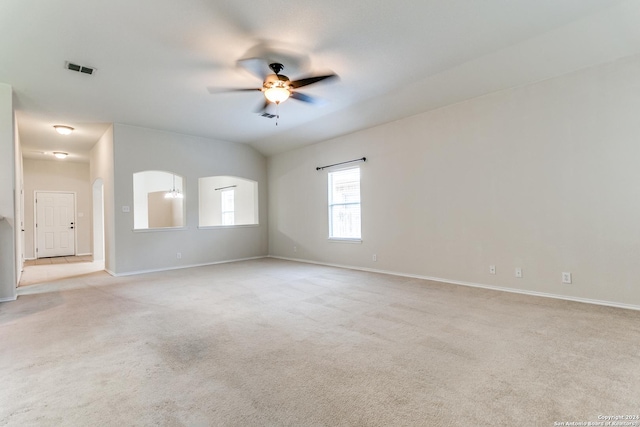 spare room with light carpet, vaulted ceiling, and ceiling fan