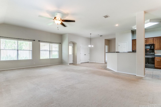 unfurnished living room with ceiling fan with notable chandelier and light carpet