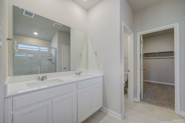 bathroom with a shower with shower door, vanity, tile patterned flooring, and toilet