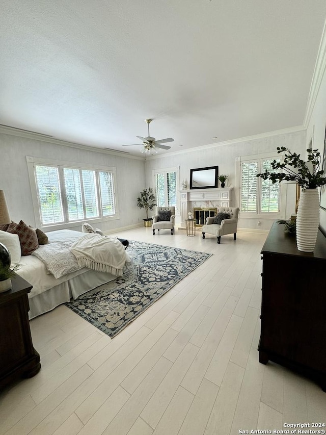 bedroom with ornamental molding, ceiling fan, and light hardwood / wood-style flooring