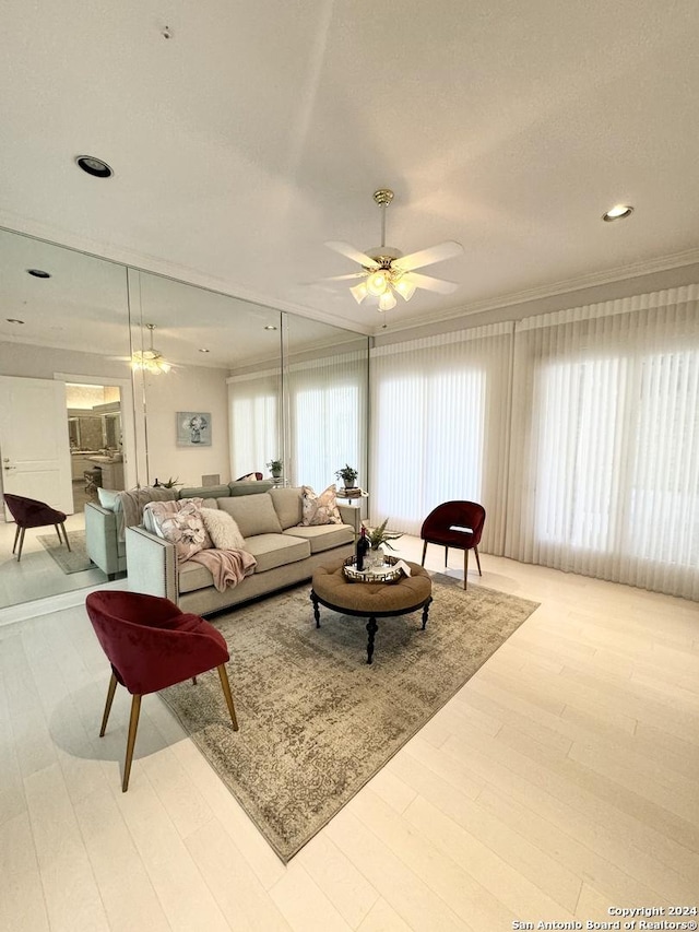 living room featuring ornamental molding, a wealth of natural light, ceiling fan, and light hardwood / wood-style floors