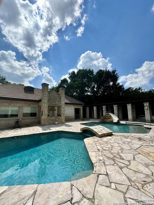 view of swimming pool featuring a patio and a water slide