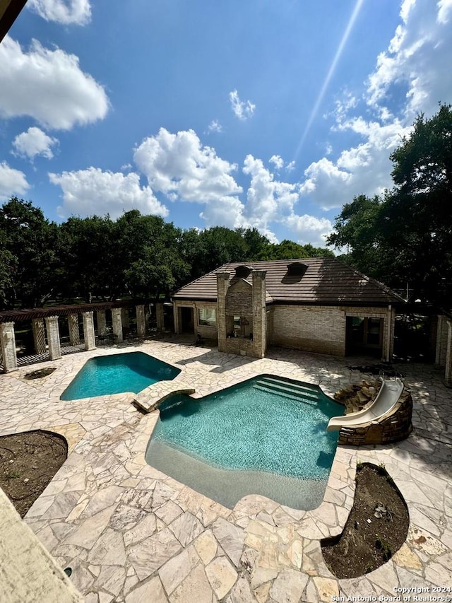 view of pool with a fireplace and a patio area