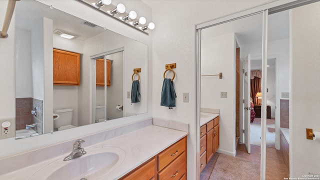 bathroom with tile patterned flooring, vanity, and toilet