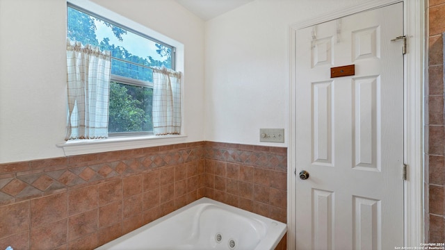 bathroom featuring a bath and tile walls