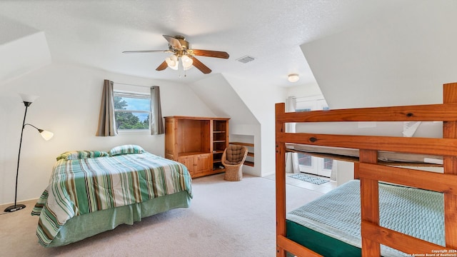 carpeted bedroom featuring ceiling fan, lofted ceiling, and a textured ceiling