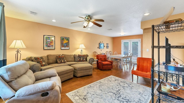 living room with hardwood / wood-style flooring, ceiling fan, a textured ceiling, and french doors