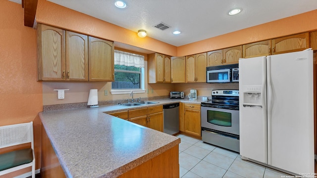 kitchen featuring light tile patterned floors, kitchen peninsula, sink, and appliances with stainless steel finishes