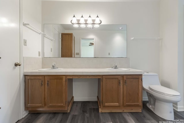 bathroom with toilet, decorative backsplash, hardwood / wood-style flooring, and vanity