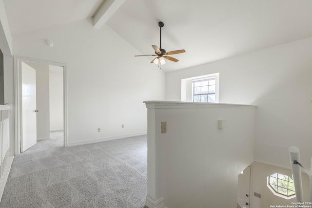 carpeted empty room featuring ceiling fan and lofted ceiling with beams