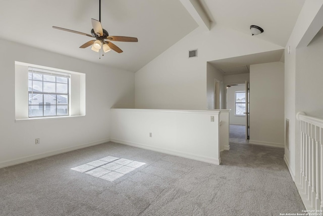 carpeted empty room featuring ceiling fan and vaulted ceiling with beams