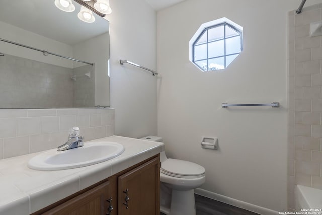 bathroom featuring decorative backsplash, hardwood / wood-style floors, toilet, and vanity