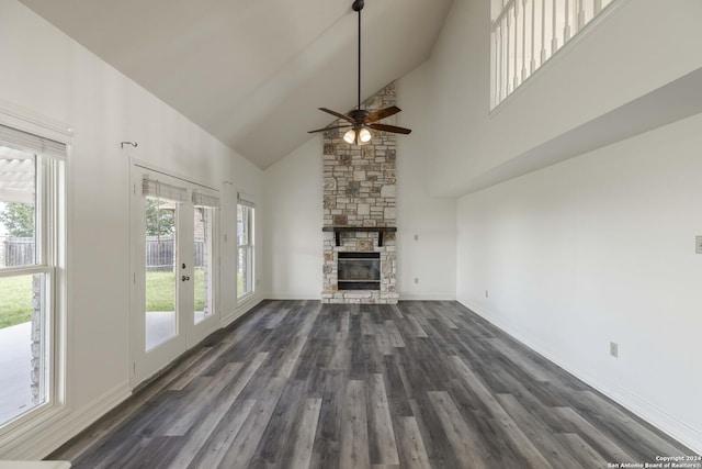 unfurnished living room with high vaulted ceiling, plenty of natural light, a fireplace, and dark wood-type flooring