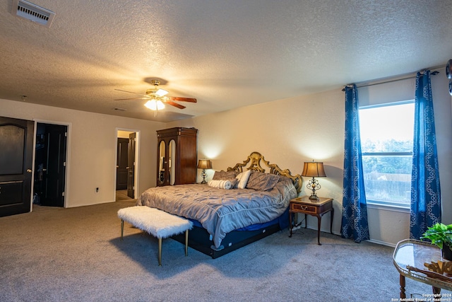 carpeted bedroom featuring a textured ceiling and ceiling fan