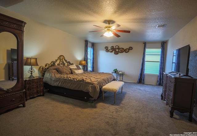 bedroom with ceiling fan, carpet flooring, and a textured ceiling