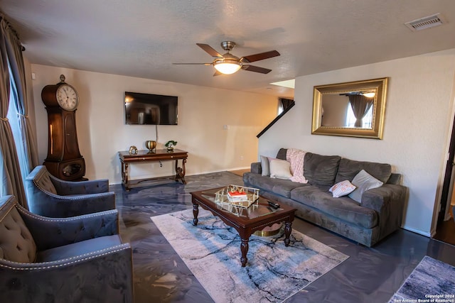 living room featuring ceiling fan and a textured ceiling