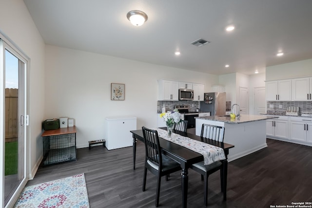 dining space featuring dark wood-type flooring and sink