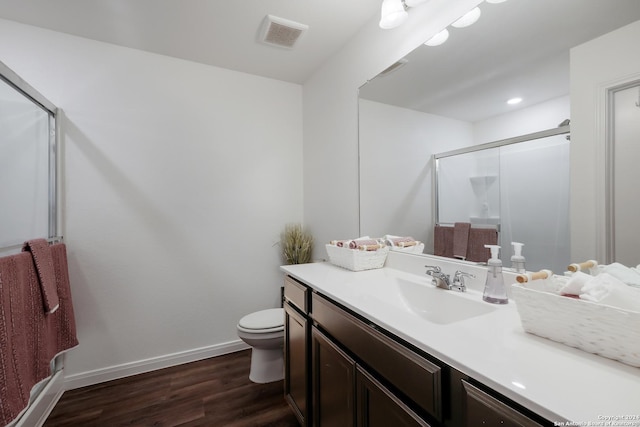 bathroom featuring toilet, a shower with door, vanity, and hardwood / wood-style flooring