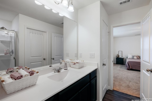 bathroom with vanity, a shower with shower door, and wood-type flooring