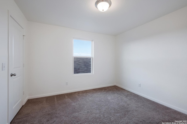 empty room featuring dark colored carpet