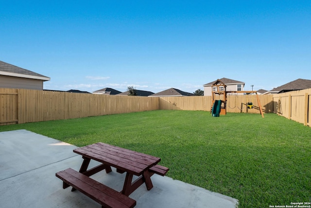 view of yard featuring a playground and a patio