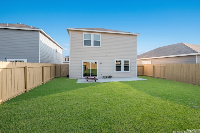 back of house with a yard and a patio