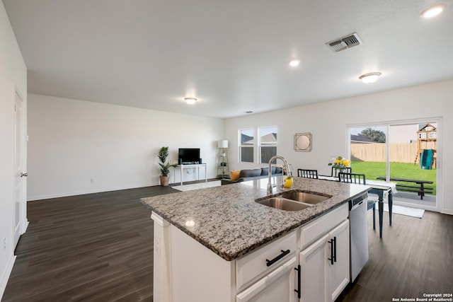 kitchen featuring light stone counters, sink, dishwasher, white cabinetry, and an island with sink