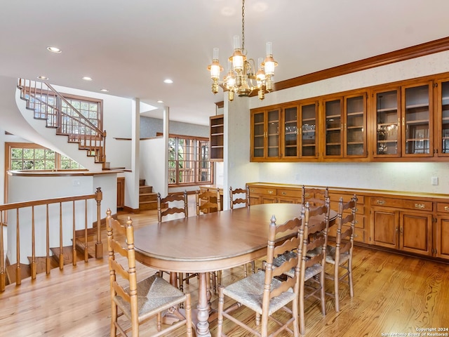 dining room featuring an inviting chandelier, light wood-type flooring, and ornamental molding