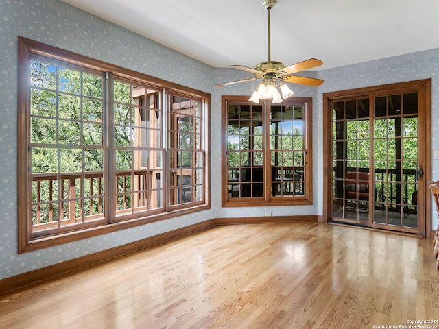 unfurnished dining area with a healthy amount of sunlight, ceiling fan, and light wood-type flooring