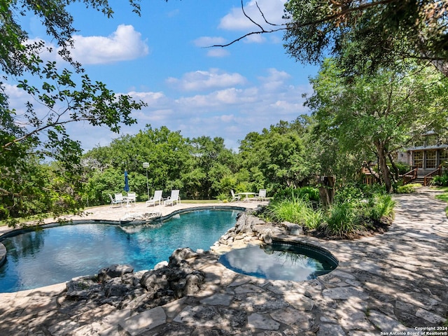 view of pool with an in ground hot tub and a patio area